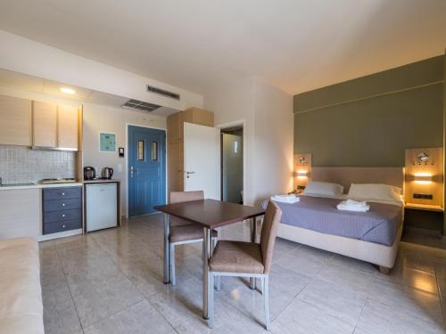 a bedroom with a bed and a table and a kitchen at Paradise Resort in Finikounta