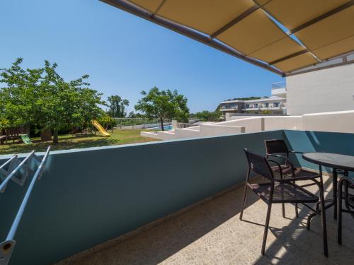 a balcony with chairs and a table on a building at Paradise Resort in Finikounta