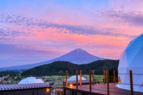 una vista di una montagna al tramonto con tende di グランファーム富士河口湖 Granfarm Fujikawaguchiko a Fujikawaguchiko
