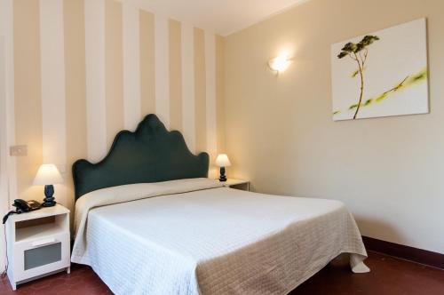 a bedroom with a bed and a striped wall at Hotel Club i Pini - Residenza d'Epoca in Versilia in Lido di Camaiore