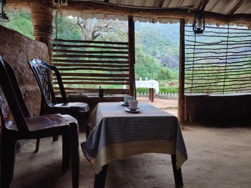 einen Tisch und einen Stuhl in einem Zimmer mit Fenster in der Unterkunft Eco Lodge Meemure & Adventure Park in Mimure