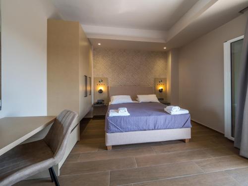 a bedroom with a bed and a chair in it at Paradise Resort in Finikounta