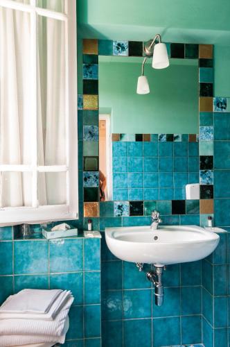 a blue tiled bathroom with a sink and a toilet at Hotel Club i Pini - Residenza d'Epoca in Versilia in Lido di Camaiore