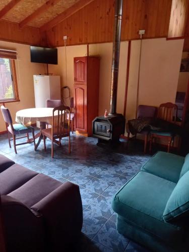 a living room with a table and a stove at Cabañas Cristobal in Licán Ray