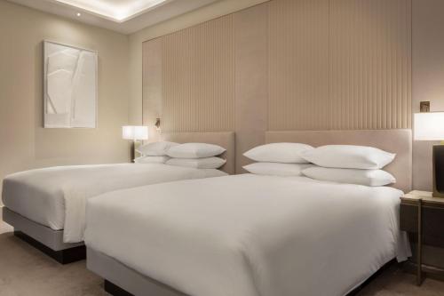 two beds in a hotel room with white pillows at JW Marriott Hotel Madrid in Madrid