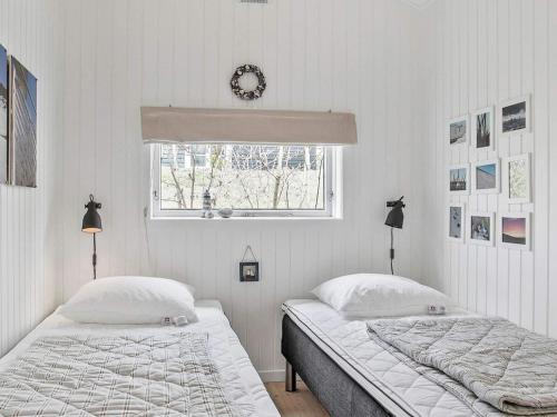 2 camas en un dormitorio blanco con ventana en Holiday home Fjerritslev IX, en Fjerritslev