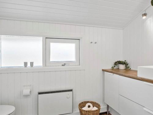 Baño blanco con lavabo y aseo en Holiday home Fjerritslev IX, en Fjerritslev