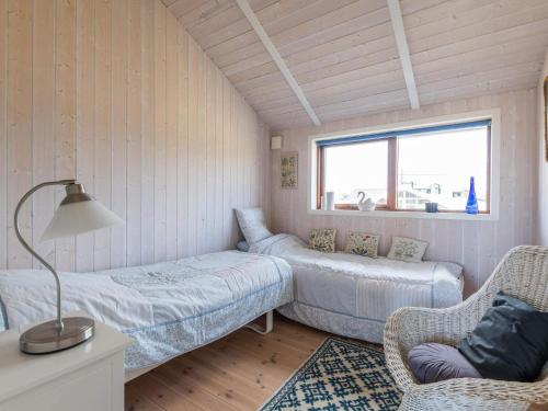 een kamer met 2 bedden, een bank en een raam bij Holiday home Fanø VII in Fanø