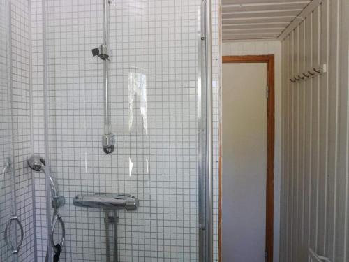 un bagno piastrellato bianco con doccia e lavandino di Holiday home ÅKERSBERGA V ad Åkersberga