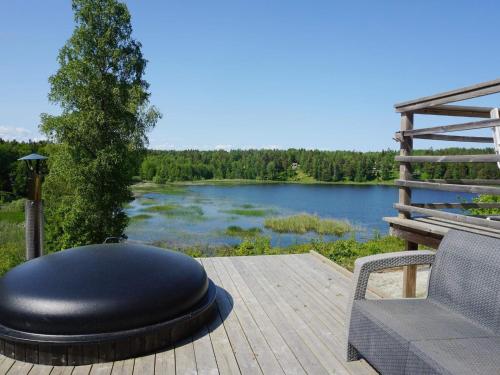 a black ottoman sitting on a deck next to a lake at 6 person holiday home in ÅKERSBERGA-By Traum in Åkersberga
