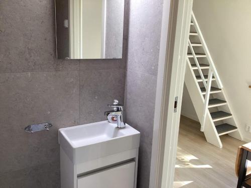 a bathroom with a white sink and a mirror at Holiday home Sölvesborg XII in Sölvesborg