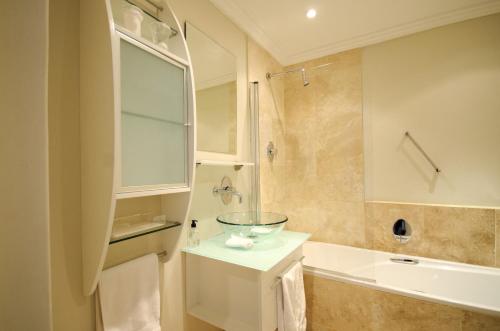 a bathroom with a sink and a glass bowl on a counter at 61 on Camps Bay in Cape Town