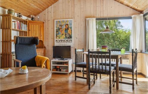 a living room with a table and chairs and a television at Three-Bedroom Holiday Home In Nakskov in Nakskov