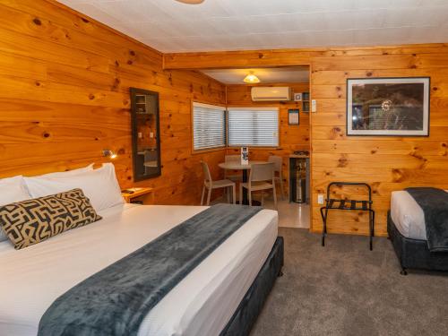 a bedroom with a bed and a table at Tasman Holiday Parks - Rotorua in Rotorua
