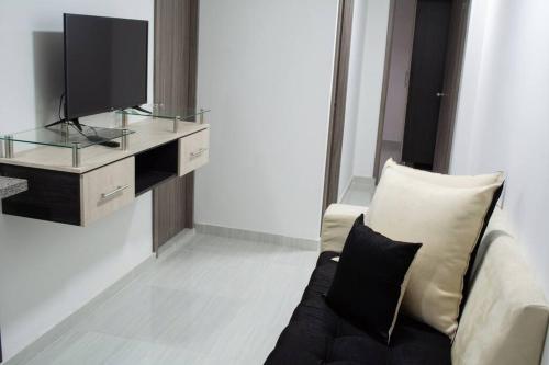 - un salon avec un canapé et une télévision dans l'établissement Apartahotel 222 Apartamento 304, à Pereira