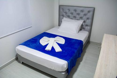 - un lit avec une couverture bleue et une archet dans l'établissement Apartahotel 222 Apartamento 304, à Pereira