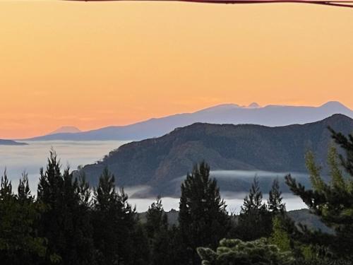 a view of a mountain range with fog in the foreground at 宿屋白金家 yadoya-shiroganeya 1日1組限定2名から8名様まで 全館貸切り 伝統的建造物の旅籠宿 Traditional culture experience in Nagano