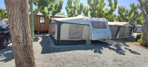 um par de tendas estacionadas num parque de estacionamento em Hotel caravana Guadalupe em Tarragona