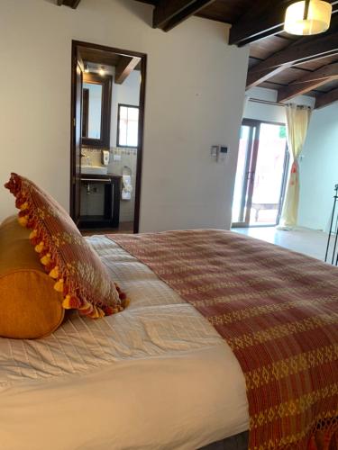 a bedroom with a bed with a comforter on it at El Calvario Lofts in Antigua Guatemala