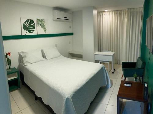 1 dormitorio con 1 cama blanca y 1 silla en Flats Asa Norte CLN 213 by CentoEdez, en Brasilia