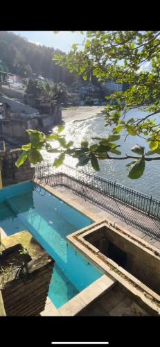 a swimming pool next to a body of water at Hostel Parque Prainha in São Vicente