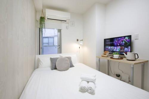 een slaapkamer met een wit bed en een bureau bij Real Kinshi 201 in Tokyo