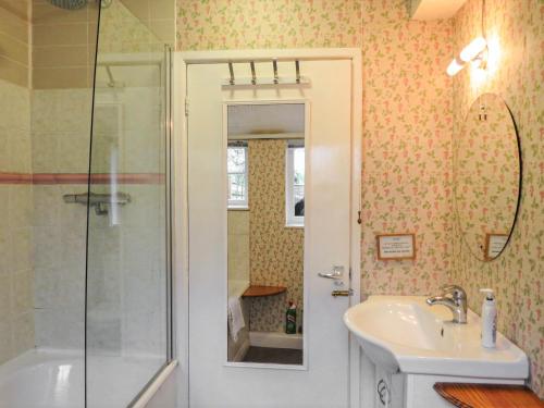 een badkamer met een wastafel en een douche bij The Old Post Office in Yellowham Wood