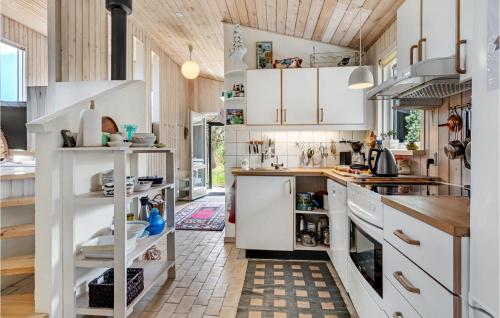 a kitchen with white cabinets and a tile floor at Awesome Home In Grenaa With Kitchen in Grenå