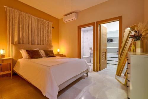 a bedroom with a white bed and a bathroom at Apartamento con piscina y parqueo, encanto urbano in Ciudad Nueva
