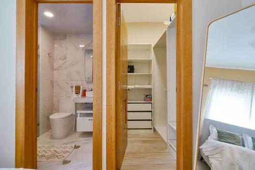 a bathroom with a toilet and a mirror at Apartamento con piscina y parqueo, encanto urbano in Ciudad Nueva