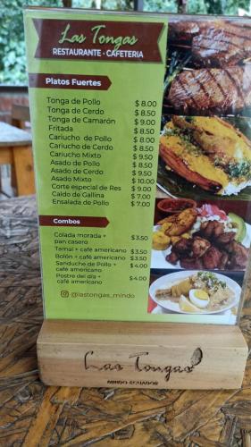 a sign for a restaurant with a menu of food at Sendero de las aves in Mindo