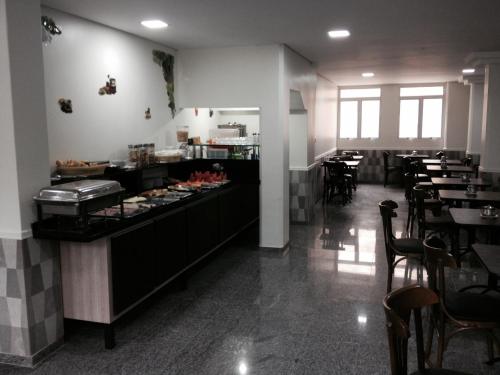 a restaurant with a counter and tables and chairs at Hotel America do Sul in Sao Paulo