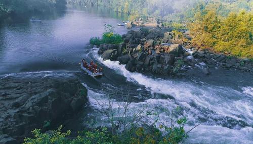 a group of people in a boat on a river at Whistling Woodzs Resort in Dandeli