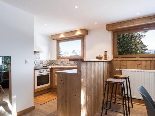 une cuisine avec des armoires en bois et un comptoir dans l'établissement Appartement montagnard 35m² - Courchevel 1850 - 2/4 pers - Centre station avec WiFi - FR-1-631-133, à Courchevel