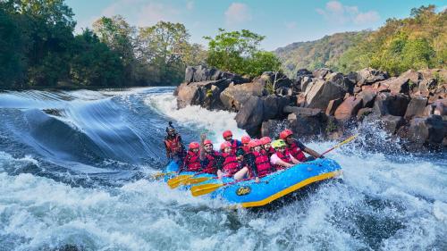 a group of people in a raft on a river at Whistling Woodzs Resort in Dandeli