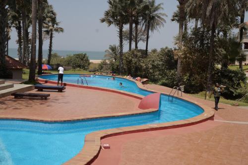 a large swimming pool with people standing around it at Lemon Creek Hotel Resort in Bijilo