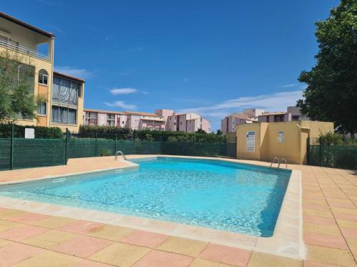 une piscine au milieu d'un immeuble dans l'établissement Spacieux Studio-Cabine avec Mezzanine, Terrasse et Piscine Commune - Cap d'Agde - FR-1-249-395, au Cap d'Agde