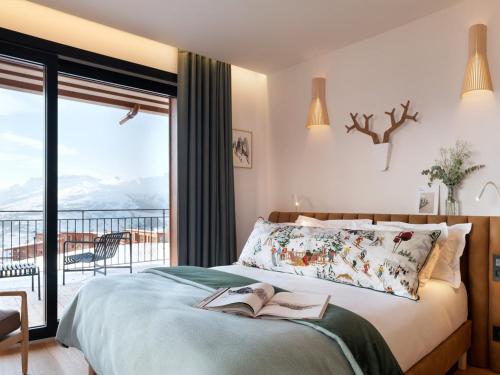 - une chambre avec un lit et un livre dans l'établissement Chalet luxe 12 pers avec piscine, sauna, hammam, home cinéma et ski aux pieds à Arc 1800 - FR-1-686-30, à Arc 1800