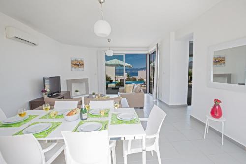a white dining room with a white table and chairs at Esprit Villa 26 Latchi in Polis Chrysochous