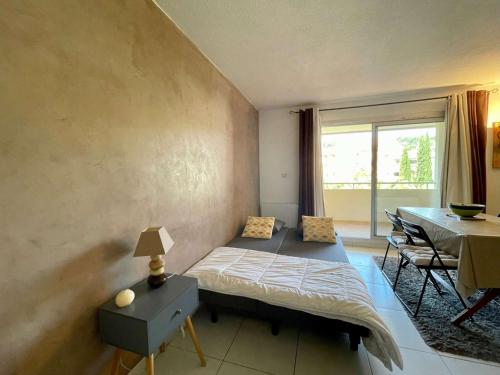 een slaapkamer met een bed en een eetkamer met een tafel bij Appartement La Croix-Valmer, 2 pièces, 4 personnes - FR-1-226B-161 in La Croix-Valmer