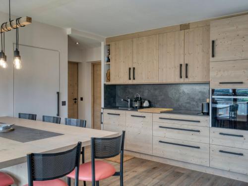 une cuisine avec des armoires en bois et une table avec des chaises dans l'établissement Confortable appartement 3 pièces avec balcon, wifi et garage à Megève - FR-1-453-306, à Megève