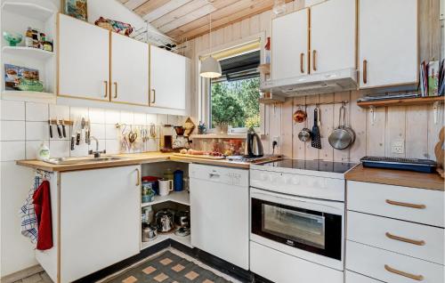 a kitchen with white cabinets and a stove at Awesome Home In Grenaa With Kitchen in Grenå