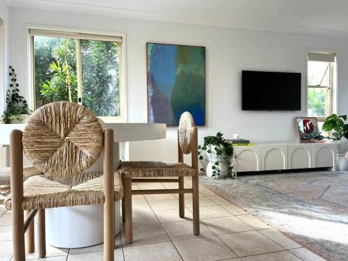 a living room with a table and two chairs and a tv at Wood Beachside Home Lennox Head in Lennox Head