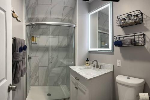 a white bathroom with a shower and a sink at Bungalow near Winnisquam Lake! Sleeps 14 in Sanbornton