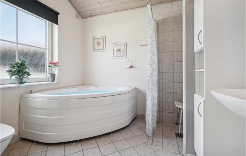 un bagno bianco con vasca e lavandino di 4 Bedroom Stunning Home In Grsten a Gråsten