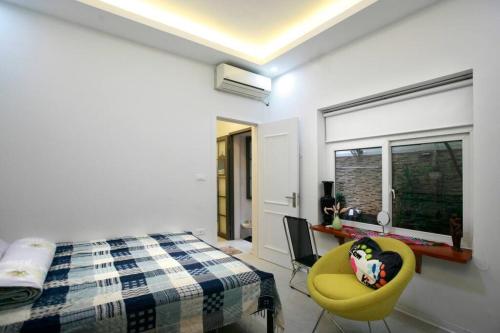 1 dormitorio con 1 cama y 1 silla amarilla en Peaceful house en Hanoi