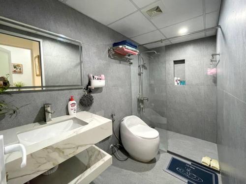 a bathroom with a sink and a toilet and a mirror at Peaceful house in Hanoi