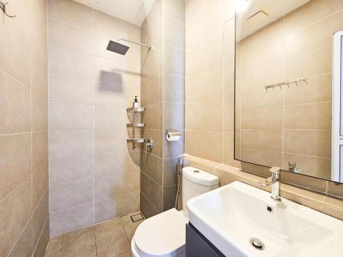 a bathroom with a toilet and a sink and a mirror at D'Pristine Theme Suite by Nest Home at LEGOLAND in Nusajaya