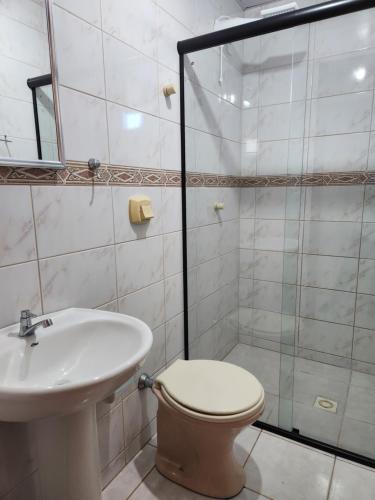 a bathroom with a shower and a toilet and a sink at 2 quartos a 200mts praia Central, GARAGEM, CHURRASQUEIRA, WI-FI 90 Mbps, PET FRIENDLY in Balneário Camboriú