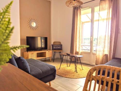 a living room with a couch and a tv at Smoothie in Canet-en-Roussillon